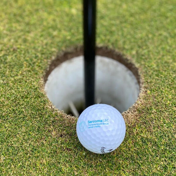 Golf ball with Sarcoma UK logo printed on it