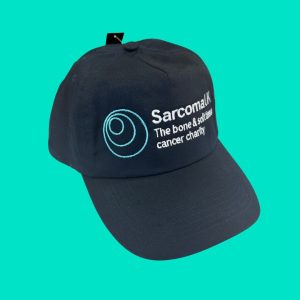 Navy baseball hat with Sarcoma UK logo on it.
